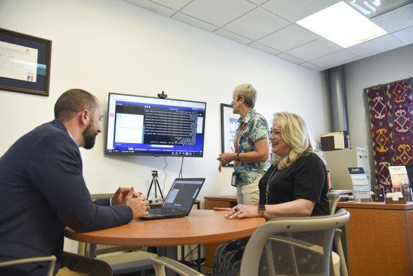 Leslie Corbo and Andrew Carr, along with Stephanie Nesbitt, Dean of 业务 and 正义 and Associate Professor of Risk Management and Insurance, brainstorm ways to improve coursework for students.