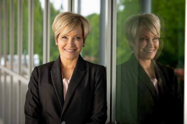 President Laura Casamento stands by a glass window, with her reflection showing in the glass next to her.